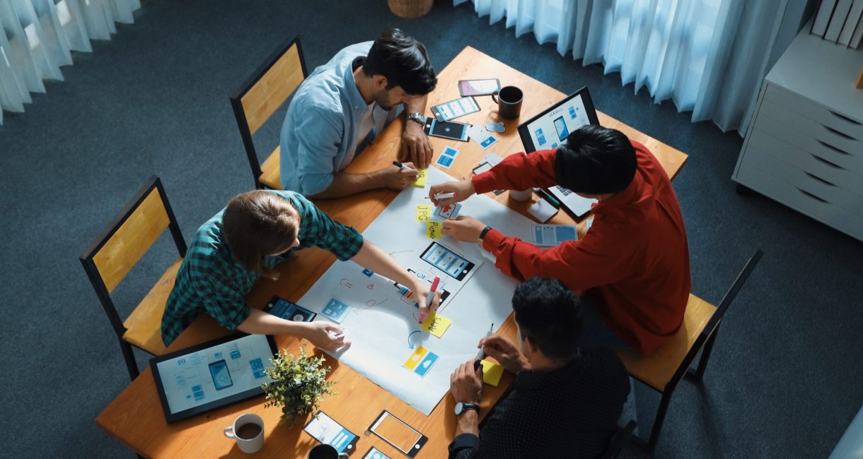 Top view of team brainstorming and sharing idea by using mind map. Convocation. Top view of professional business team brainstorming and sharing idea by using mind map. Diverse people planning marketing strategy or designing Ux Ui design for mobile phone at meeting. Convocation.